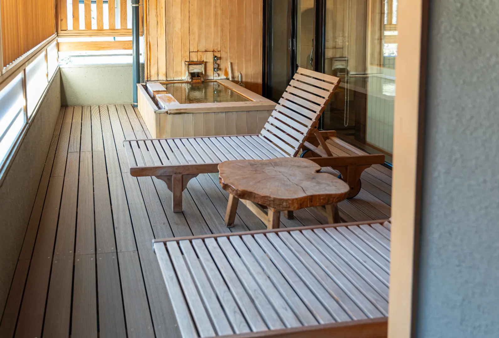 Cedar decking on a covered outdoor patio with wooden lounge furniture